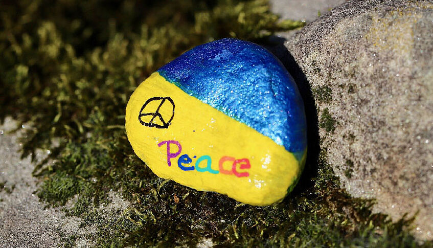 Blau und gelb bemalter Stein mit Peace-Zeichen