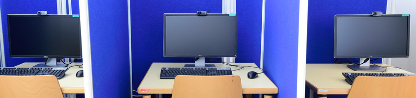 Three computer-desks partitioned by mobile walls